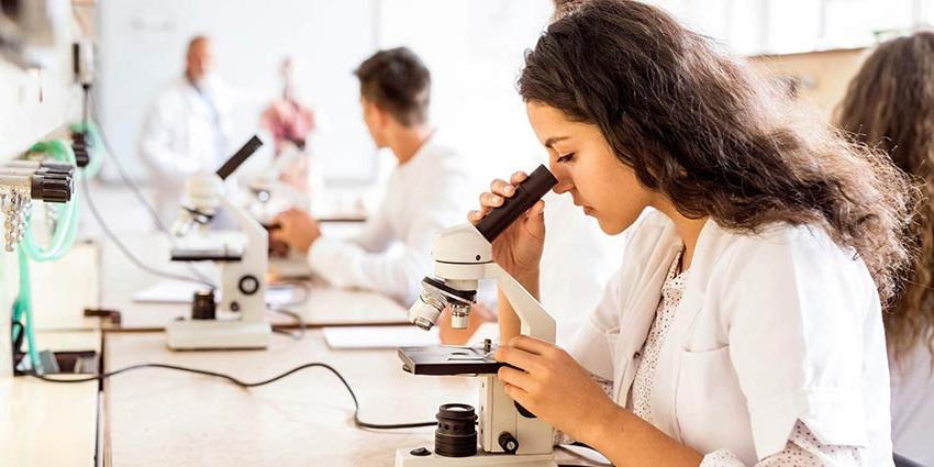 一位生物学学士学位课程的学生正在观察显微镜